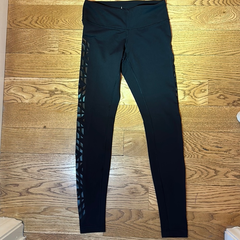 NWOT, women’s Lululemon black leggings, with patterned sides. Size 6.